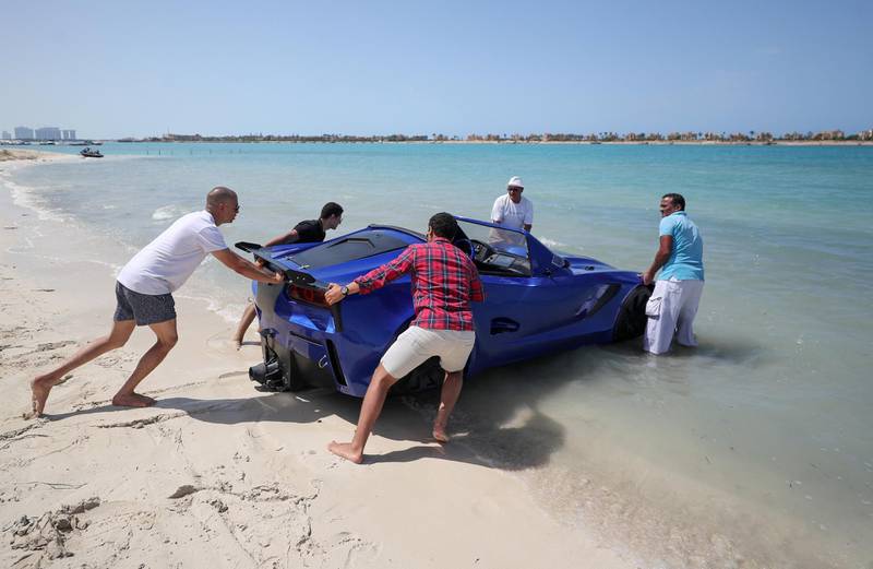 Volunteers help to launch a car that can drive on water at Porto Marina in Alexandria, Egypt. Reuters