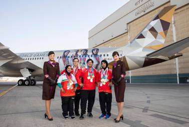 The four UAE Special Olympics athletes, Mariam Al Hosani, Omar Al Shami, Saleh Almarri, and Hamda Alhosani in front of the Etihad Airways Boeing 787-9. Courtesy Etihad