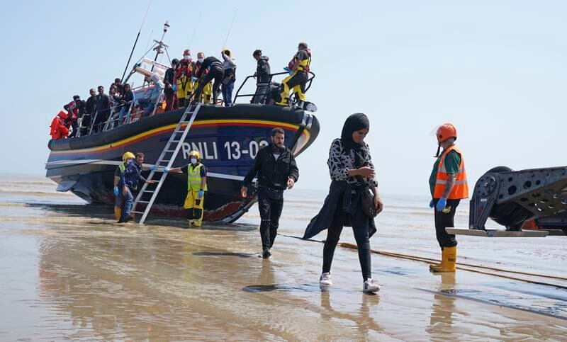A group of people thought to be migrants crossing from France, come ashore aboard the local lifeboat at Dungeness, southern England, Tuesday July 20, 2021.   The group or people were picked up by lifeboat following a small boat incident in the English Channel.   (Gareth Fuller / PA via AP)