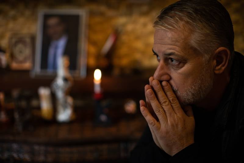 Kayan Tleiss sits in front of the shrine dedicated to his brother in his living room in Khalde, in the southern suburbs of Beirut.
