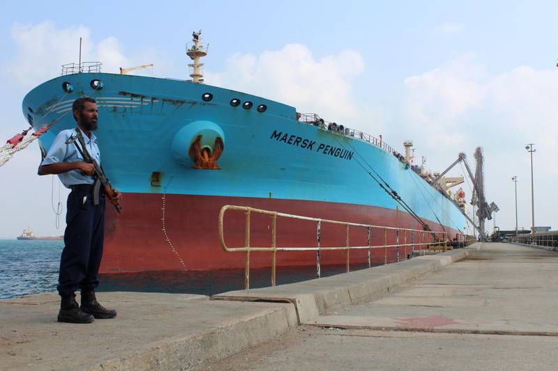 A security guard stands by a ship in port.