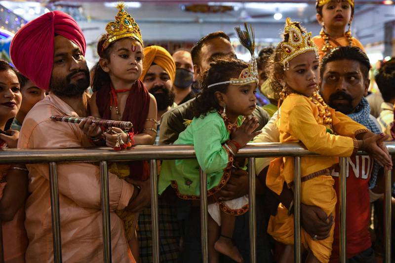 Devotees carry their children dressed as Krishna at Shivala Bhaiyaan temple in Amritsar. AFP