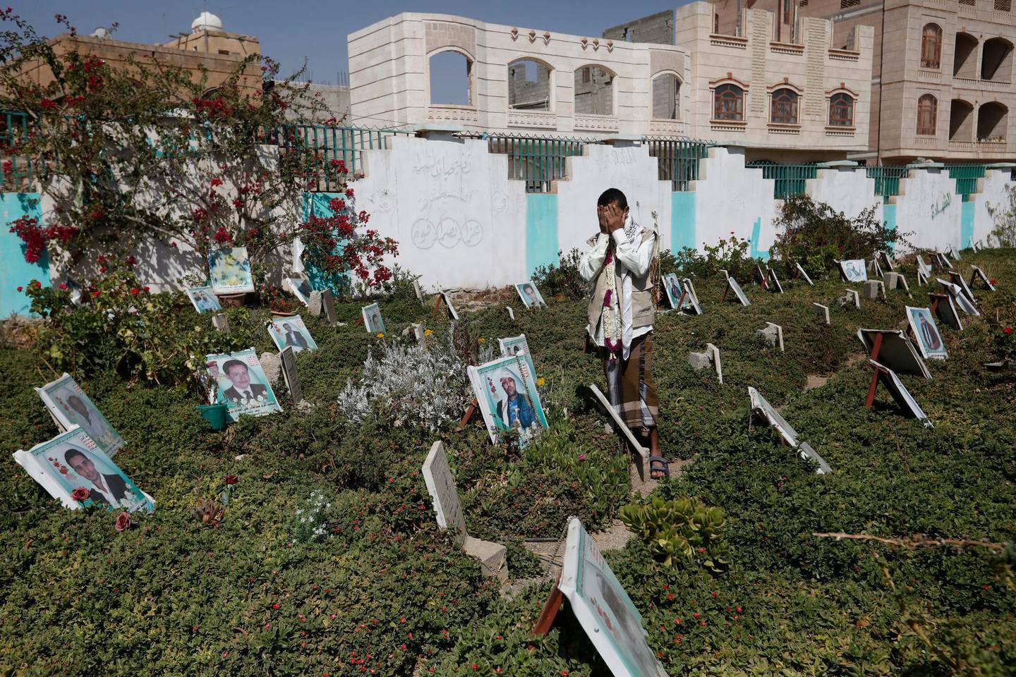 epa09048800 Recently released-Houthi prisoner Abdullah Al-Muntasir prays at the graves of his slain comrades who were killed in ongoing fighting, at a cemetery in Sana'a, Yemen, 03 March 2021. Abdullah Al-Muntasir was recently released as part of a local mediator-brokered prisoner swap deal with the Saudi-backed government forces in the oil-rich province of Marib which has been in the grip of an escalating fighting between both warring sides.  EPA/YAHYA ARHAB