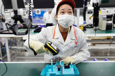 An employee looks at instructions displayed on an overhead screen while assembling a ventilator on the production line at the Vinsmart factory n Hanoi, Vietnam. Bloomberg