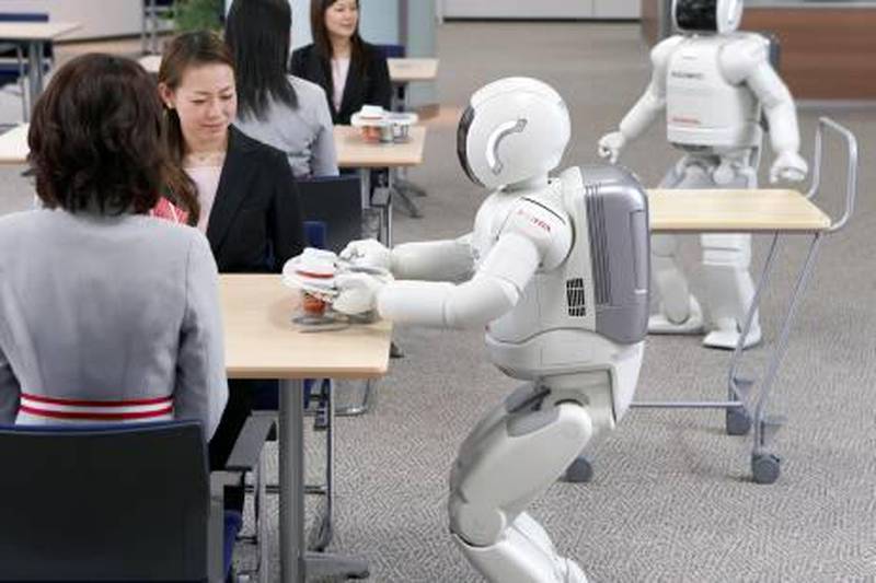 This handout picture, released from Japanese auto giant Honda Motor 11 December 2007, shows the company's humanoid robot Asimo serving tea to Honda employees, as Honda unveiles an updated version of Asimo which can operate multiple Asimos to share tasks together in coordination to provide uninterrupted service. Honda will start its trial service at the company's headquarters from 12 December. RESTRICTED TO EDITORIAL USE AFP PHOTO / HONDA MOTOR / HO