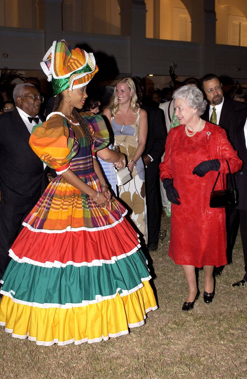 Queen Elizabeth II, wearing a red silk-embossed chiffon dress by Karl Ludwig, attending a reception at King's House, Jamaica on February 18, 2002. Getty Images
