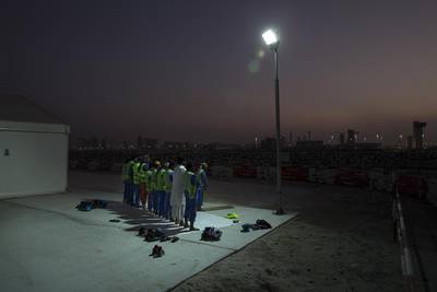 Workers pray during their Maghrib prayer on the construction site at the Louvre Abu Dhabi. Silvia Razgova / The National