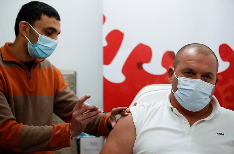 A man receives a Covid-19 vaccine at Regent Pharmacy in Northampton. There are concerns over a sluggish booster shot programme for over-50s and low uptake of vaccines among 12 to 15-year-olds. Reuters