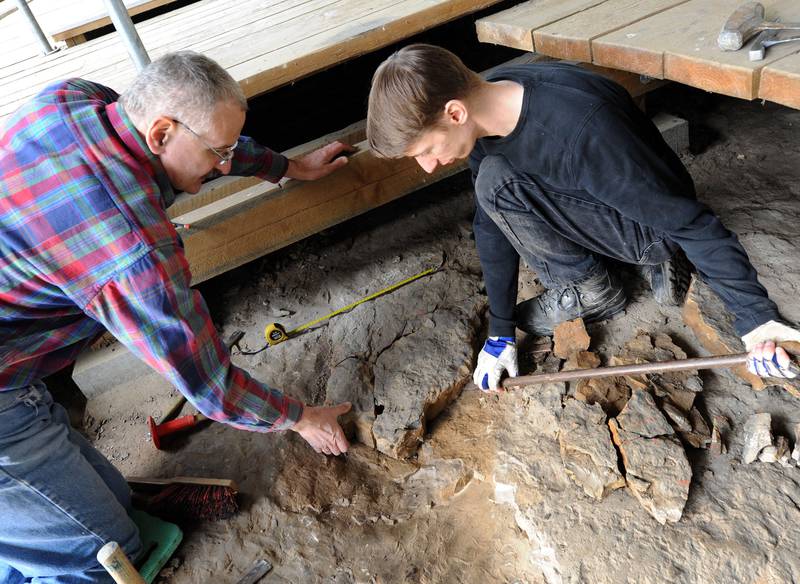Scientists Martin Sander, left, and Benjamin Englich examine the footprint of a long-necked dinosaur at an open-air museum in Germany in March 2012. EPA