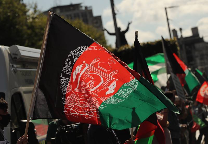 People wave Afghan flags during a protest. Charity workers have accused the British government of doing too little to help at-risk Afghans who have been in hiding since the Taliban's takeover of Kabul. PA