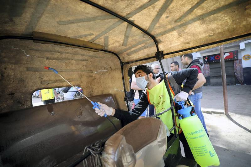 epa08341415 A member of a medical team sprays disinfectant as a precaution against the coronavirus outbreak at a tuk-tuk three wheel motorcycle in Shobra district in Cairo, Egypt, 03 April 2020.  Egyptian authorities have imposed a two-week-long curfew, starting on 25 March, during which all public transportation in the city is suspended due to the ongoing pandemic of the Covid-19 disease caused by the SARS-CoV-2 coronavirus.  EPA/KHALED ELFIQI