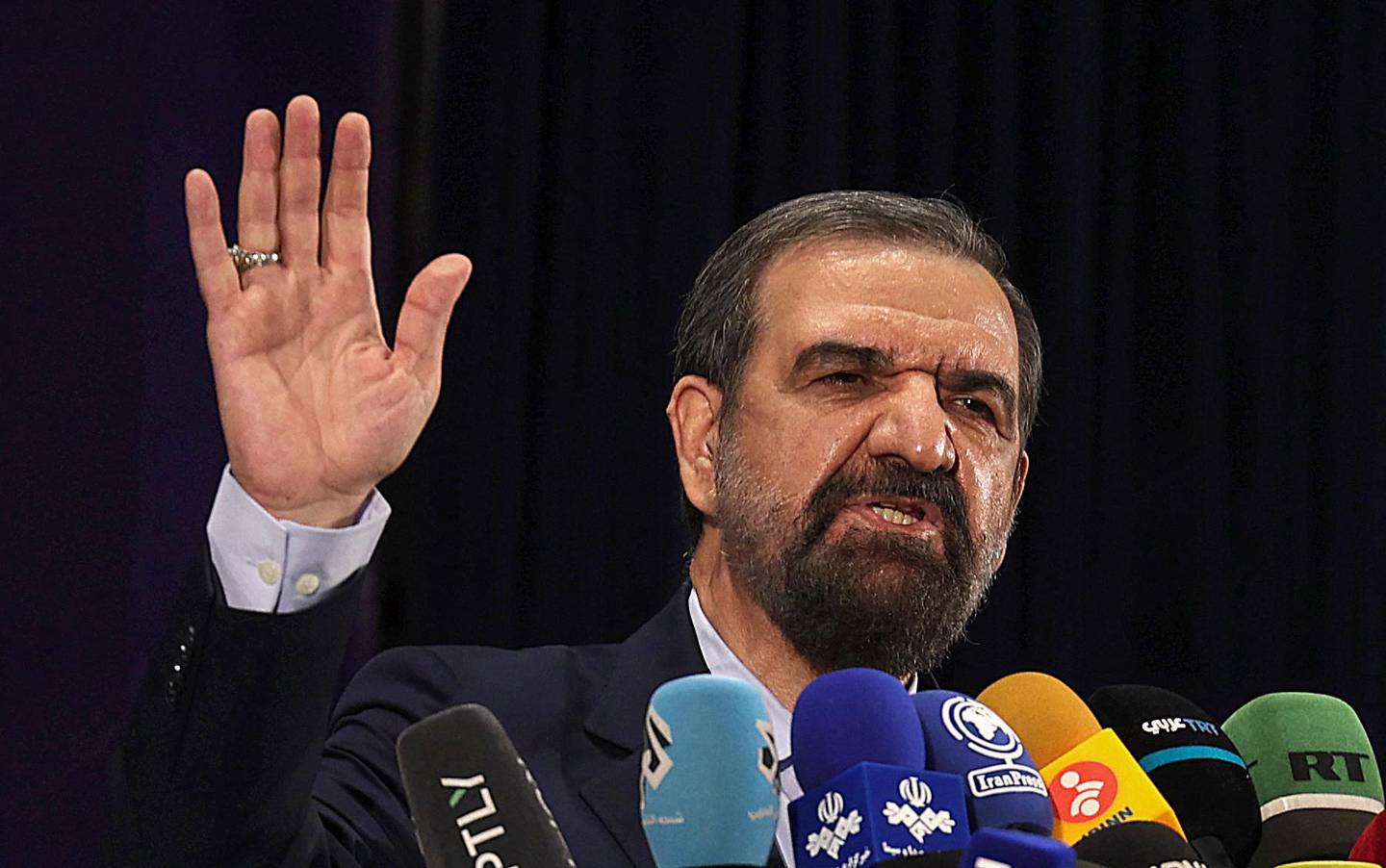 Iranian former chief of the Revolutionary Guards Mohsen Rezai talks to the media after registering his candidacy for the June presidential elections, at the Interior Ministry in the capital Tehran, on May 15, 2021. (Photo by ATTA KENARE / AFP)