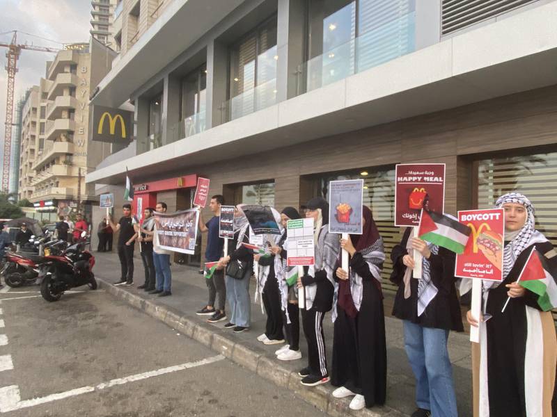 Activists hold signs outside McDonald's in Beirut. Photo: Abbas Atout.