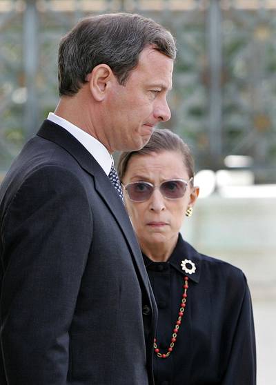 US President George W Bush's nominee to be Chief Justice of the Supreme Court, Judge John Roberts, walks past Associate Supreme Court Justice Ruth Bader Ginsburg on the steps of the court in Washington on September 6, 2005. AFP