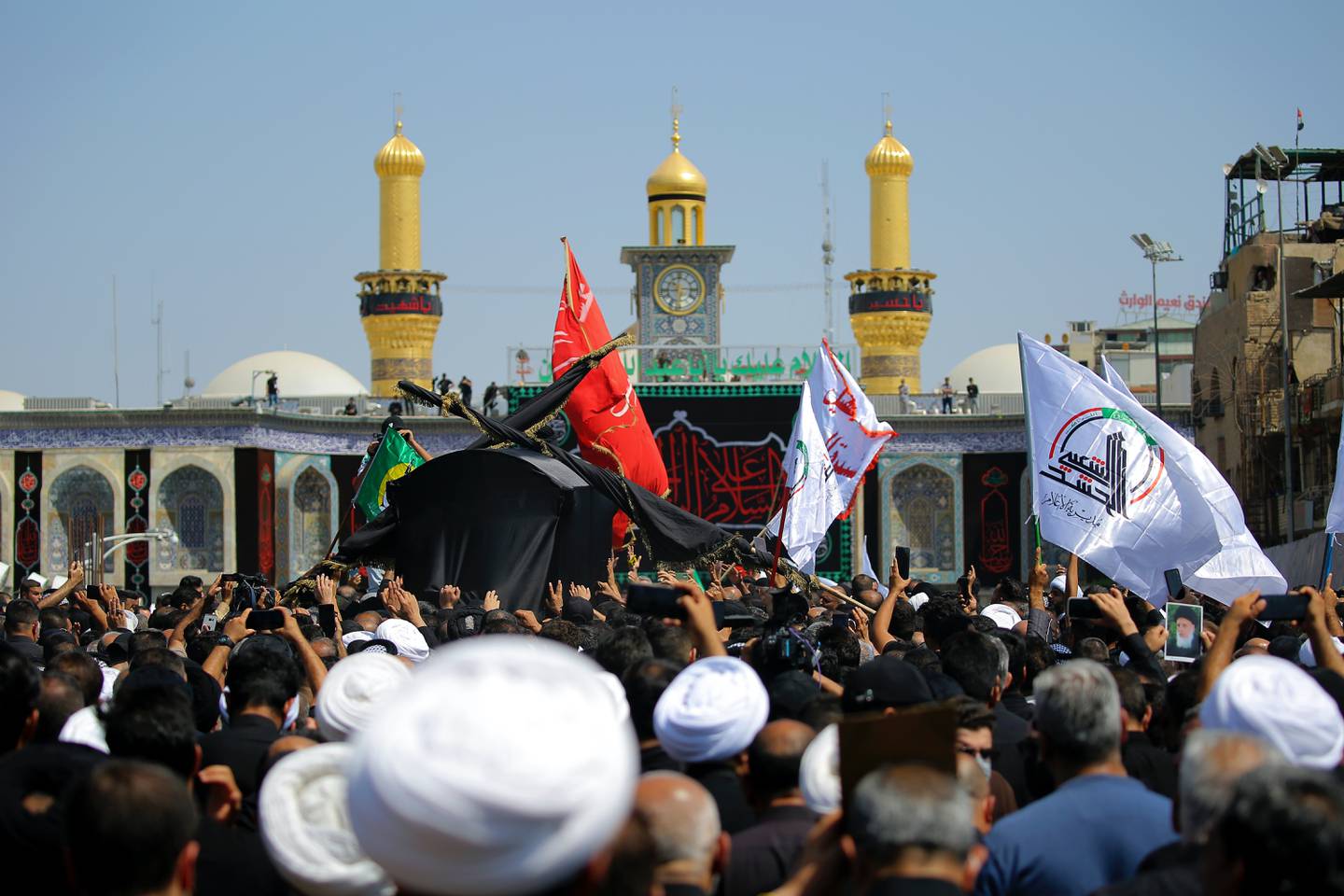 Mourners carry the coffin of Grand Ayatollah Mohammed Saeed Al Hakim outside the shrine of Imam Hussein in Karbala, Iraq. Photo: AP 
