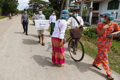 Officers and volunteers from Union Election Commission walk to collect ballots from elderly people who make an early voting on the outskirts of Yangon. AP Photo