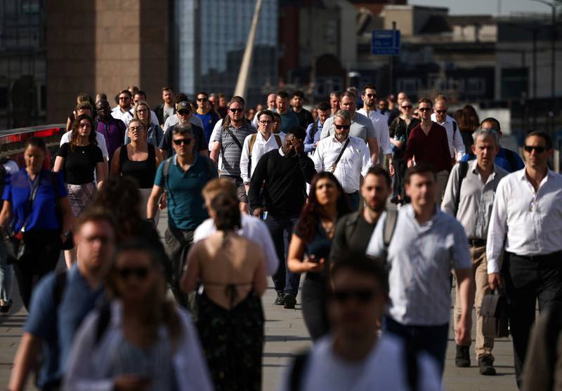 Commuters walk over London Bridge in London. Higher wages are feeding through to tax receipts. Reuters