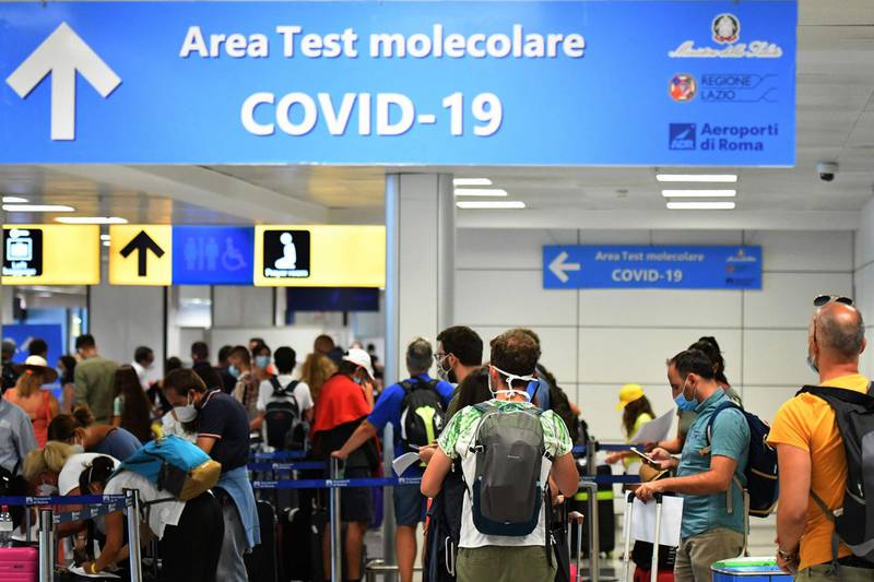 Passengers queue to be screened for Covid-19 at a testing station set up at Fiumicino airport, near Rome, on August 16, 2020.  Italy has introduced mandatory Covid-19 (novel coronavirus) testing for anyone arriving from Croatia, Greece, Spain and Malta and banned all visitors from Colombia, in a bid to rein in new infections. / AFP / Alberto PIZZOLI
