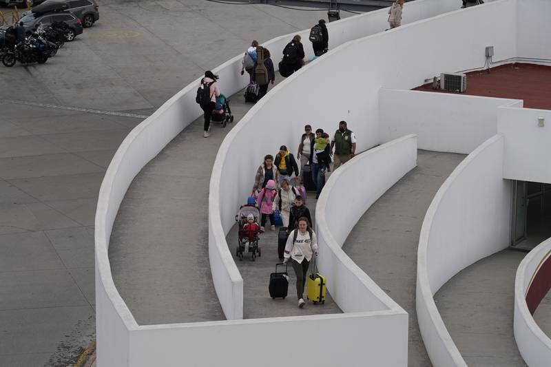 Ukrainian refugees walk up the pedestrian ramp to the PedWest point of entry into the United States.