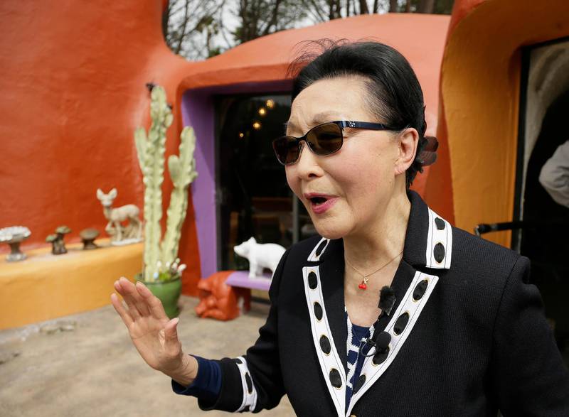 Homeowner Florence Fang talks with reporters after a news conference outside her Flintstone House. AP