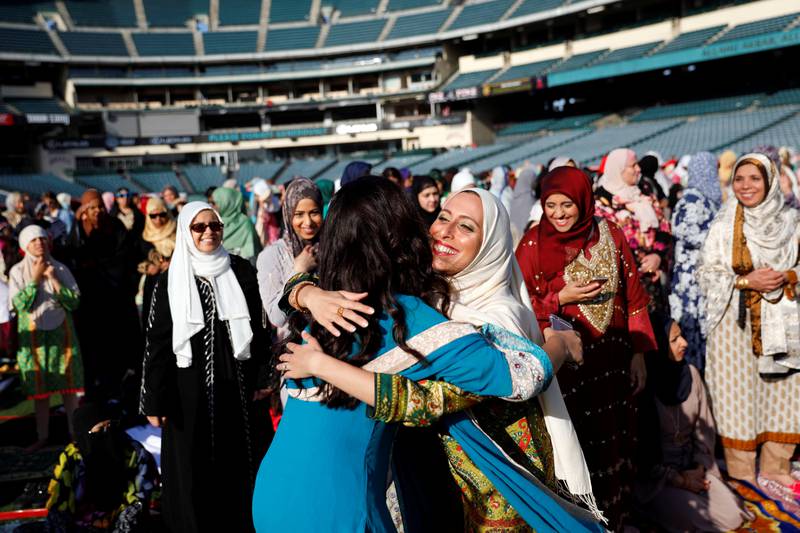 Muslim women hug as they gather for the Eid Al Fitr holiday, the end of Ramadan, at Angel Stadium in Anaheim, California. AFP