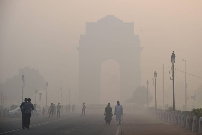 Indian pedestrians walking near the India Gate monument amid heavy smog in New Delhi on October 20, 2017, the day after the Diwali Festival.
New Delhi was shrouded in a thick blanket of toxic smog a day after millions of Indians lit firecrackers to mark the Diwali FestivaL. / AFP PHOTO / DOMINIQUE FAGET