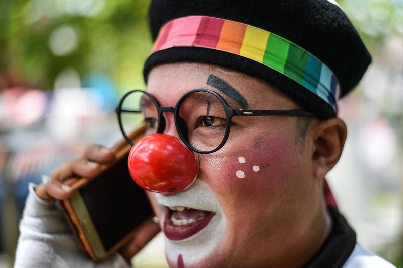 Mohamad Fadly Abu Hasan, a 37-year-old clown entertainer, talks on his smartphone after performing at a kindergarten in Kuala Lumpur. AFP