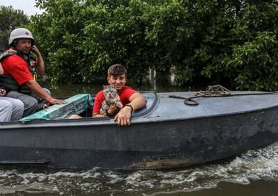 A volounteer smiles after saving an animal from a flooded area of Kherson, Ukraine. EPA