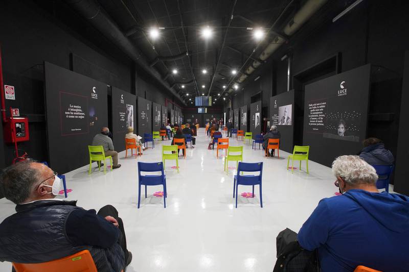 People sit in a waiting room after receiving a dose of the Pfizer vaccine, at a vaccination center set up at Rome's Cinecitta' film studios in Italy. AP Photo