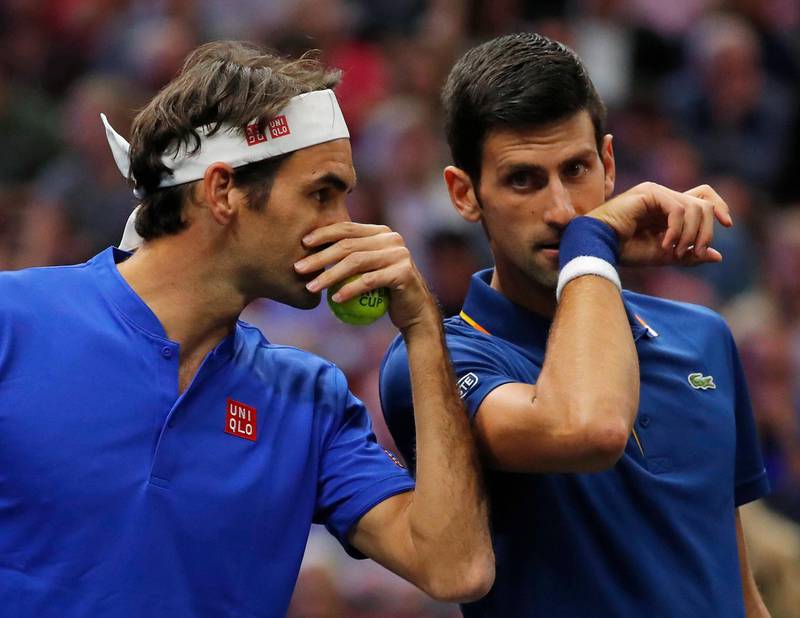 Team Europe's Roger Federer, left, whispers to Novak Djokovic during a men's doubles tennis match against Team World's Jack Sock and Kevin Anderson at the Laver Cup, Friday, Sept. 21, 2018, in Chicago. (AP Photo/Jim Young)