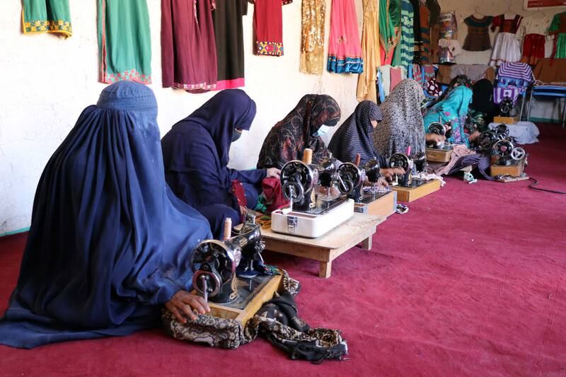 Afghan women working at a tailoring shop in Kandahar, in May 2022.   Razia, an Afghan woman, employs about 50 women who earn around US$35 a month to help support their families. EPA
