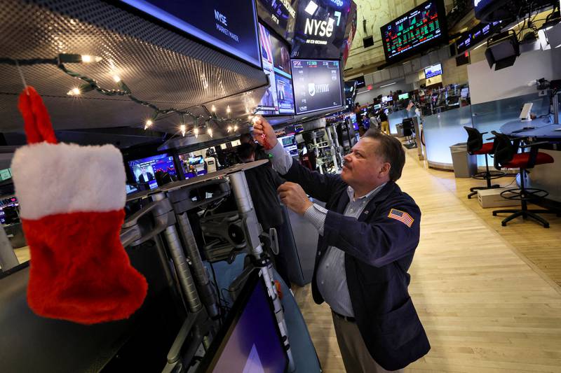A trader hangs Christmas decorations at the New York Stock Exchange. Markets opened in risk-on mode this week after Covid restrictions were eased in China. Reuters