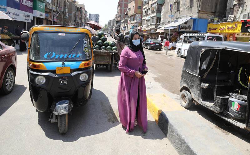 An Egyptian woman wearing a face mask walks at Bolaq district in Giza, Egypt.  EPA