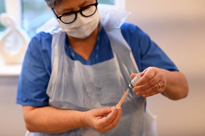NHS advanced nurse practitioner Edwina Williams prepares a phial of the Oxford/Astrazeneca Covid-19 vaccine before it is administered to residents at Belong Crewe care village in Crewe, northwest England on January 14, 2021. The government has come under increasing pressure to speed up its vaccination programme, and is now reported to be planning a pilot scheme to see if there is demand for late-night jabs. / AFP / Oli SCARFF
