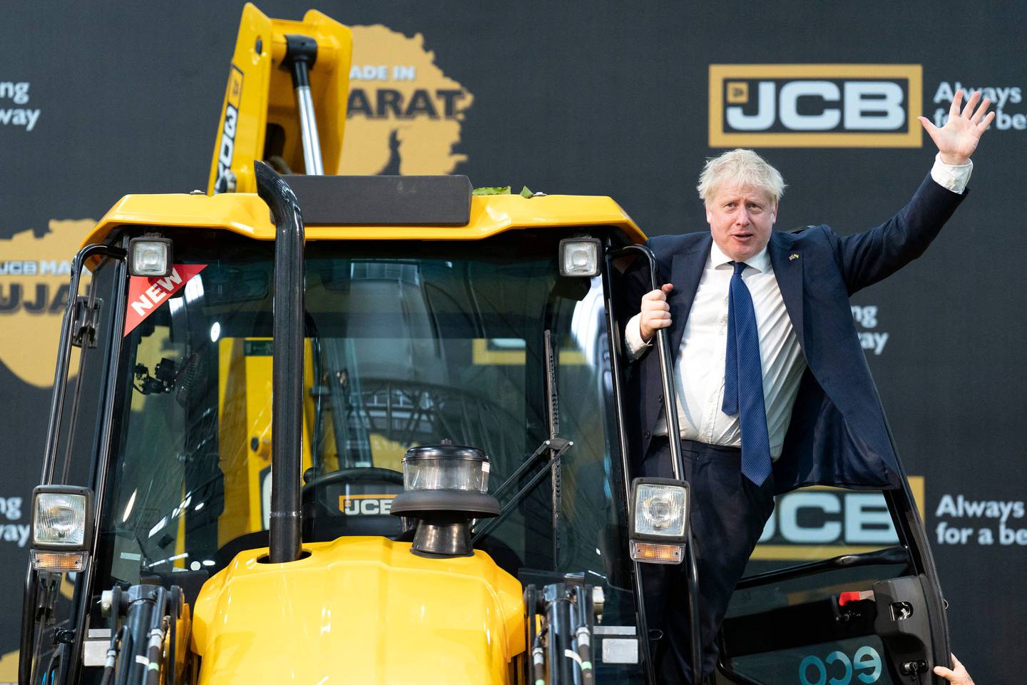 Britain's Prime Minister Boris Johnson waves from an excavator during his visit to the JCB factory in Vadodara. AFP 