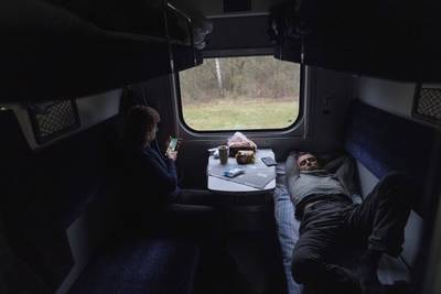 Passengers rest on the train minutes before arriving in Lviv from Kyiv. AP