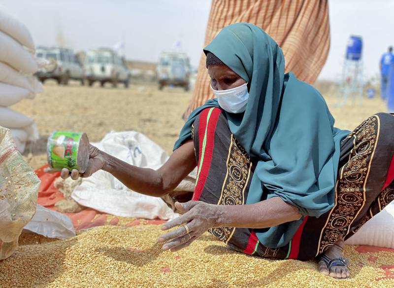 An Ethiopian woman sifts through distributed food supplies in a camp for the internally displaced in Adadle, in the Somali Region of Ethiopia. WFP via AP