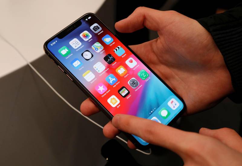 FILE PHOTO: A customer tests a smartphone during the launch of the new iPhone XS and XS Max sales at "re:Store" Apple reseller shop in Moscow, Russia September 28, 2018. REUTERS/Tatyana Makeyeva -/File Photo