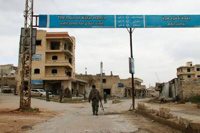 Syrian army soldiers walk in the town of Kafr Hamra in the northern Aleppo countryside.  AFP
