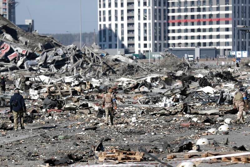 Ukrainian soldiers inspect the site of the shopping centre that was destroyed in a Russian attack in Kyiv on Monday. EPA