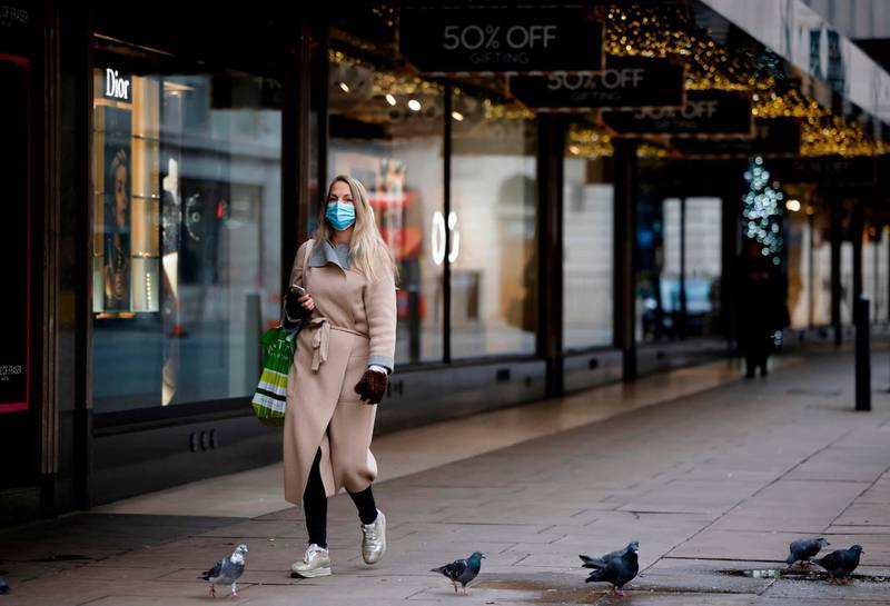 A pedestrian walks past a closed store in central London. AFP