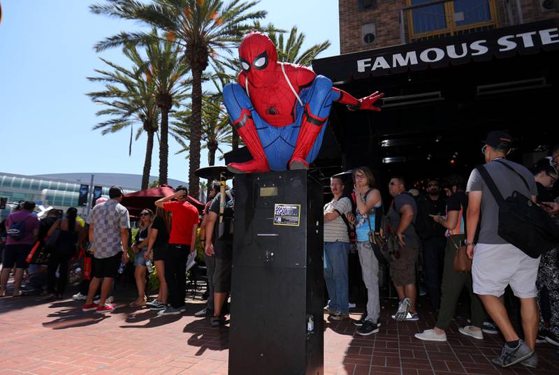 An attendee dressed as Spider-Man sits along a city street outside Comic Con International in San Diego. Mike Blake / Reuters