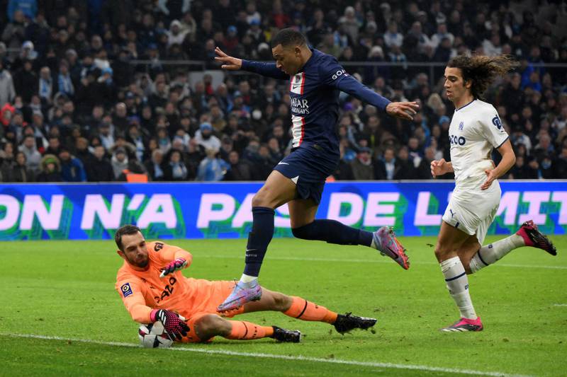 Marseille goalkeeper Pau Lopez catches the ball in front of Paris Saint-Germain forward Kylian Mbappe. AFP