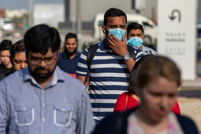 Commuters, wearing protective face masks, walk in downtown Dubai, on March 5. Bloomberg