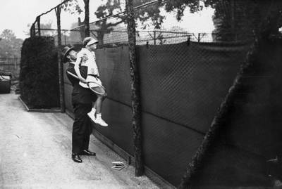 Diana Waring, 11, is lifted up for a view of the Junior Tennis Championships of Great Britain at the All England Lawn Tennis Club in 1930.