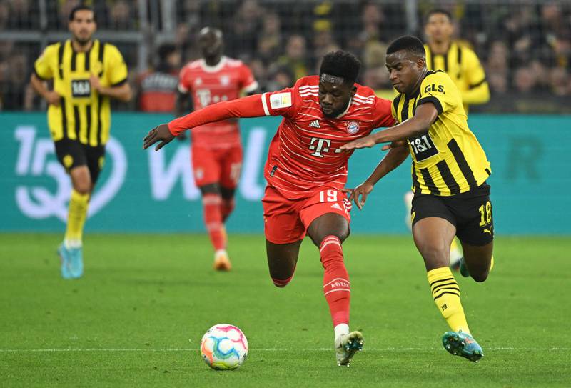 Bayern Munich's Alphonso Davies and Dortmund's Youssoufa Moukoko vie for the bal. AFP