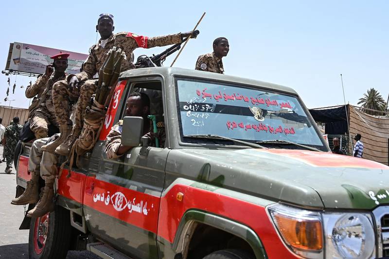 Sudanese soldiers stand guard on an armoured military vehicle as demonstrators continue their sit-in outside the army headquarters in the capital Khartoum on April 28, 2019. Sudanese protesters welcomed today a breakthrough in talks with army rulers who agreed to form a joint civilian-military council, paving the way for the civilian administration demanded by demonstrators. / AFP / OZAN KOSE
