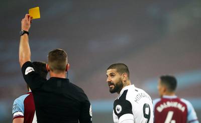 Referee Robert Jones shows yellow card to Aleksandar Mitrovic of Fulham during the match against West Ham. EPA