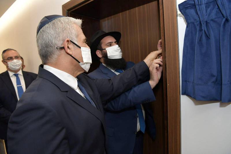 Israeli Foreign Minister Yair Lapid helps to affix a mezuzah, a ritual scroll fastened to the doorways of Jewish homes, during an inauguration ceremony at Israel's embassy in Abu Dhabi. Reuters