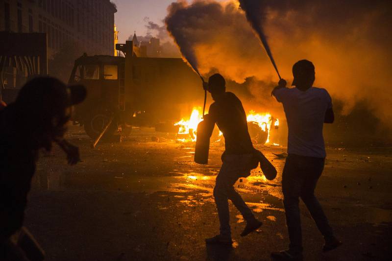 Protesters use fire extinguishers to block protesters' movements from the Internal Security Forces, not pictured, during a protest at Martyrs Square. Getty Images